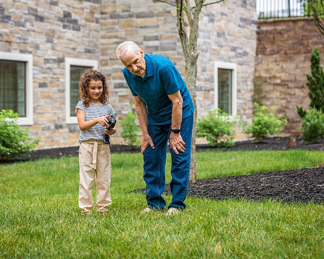 grandpa and granddaughter playing with toy car