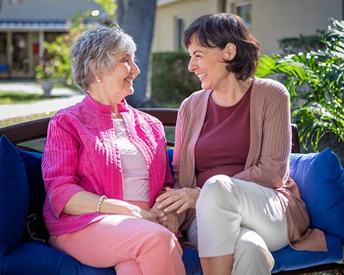 mother and daughter sitting outside on bench