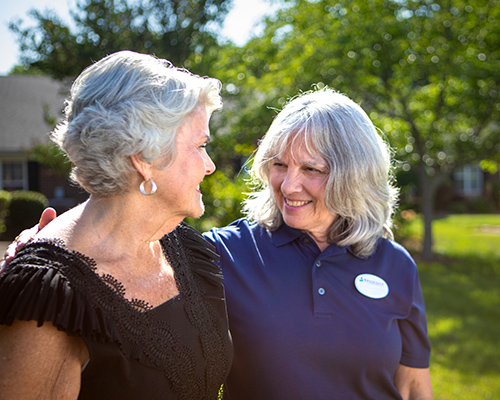 Caregiver walking with arm around resident