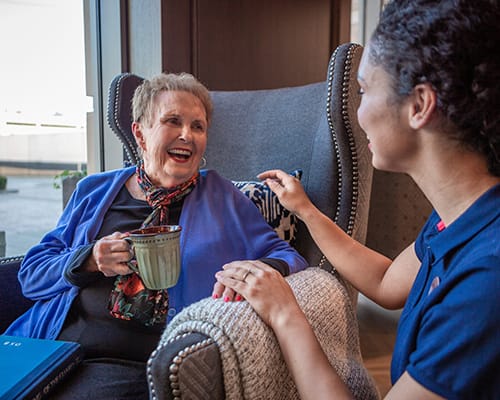 woman typing with smiling caregiver