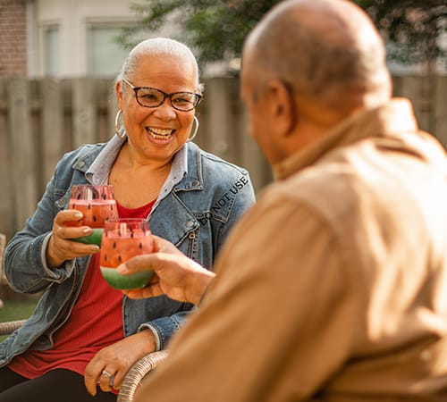 man and woman cheers drinks