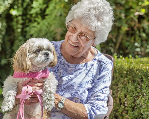 caregiver with couple sitting in courtyard
