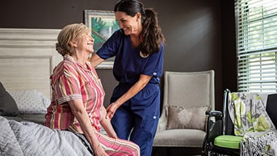 caregiver helping resident out of bed