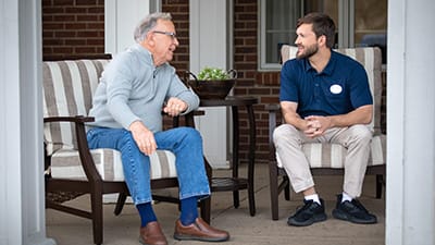 associate and man sitting on porch