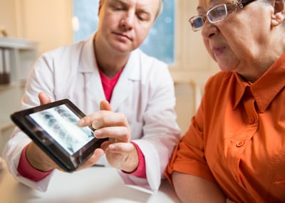 senior looking at X-ray on tablet