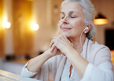 Senior listening to music through headphones