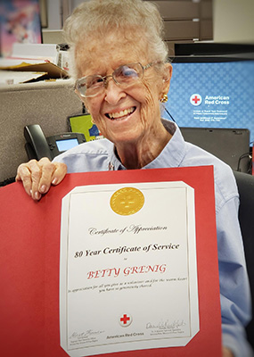 Betty smiles with her service award certificate.