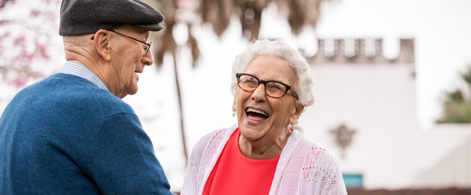 Senior couple laughing while holding each other.