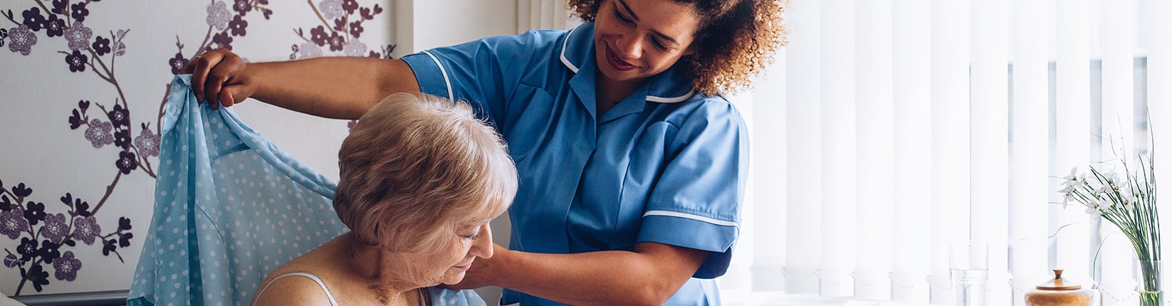 caregiver helping woman with shirt