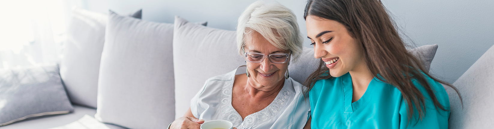 woman drinking tea with caregiver