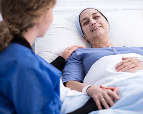 nurse with woman in hospital bed