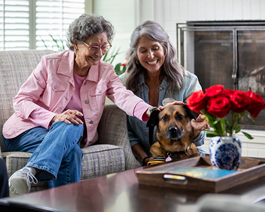 Caregiver and resident petting dog