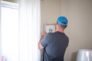  Design team member hangs artwork on wall