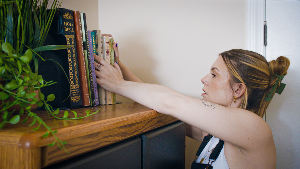  Team member organizing book shelf.