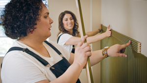  Team members hanging up wood paneling.