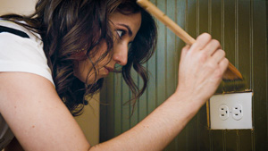  Team member painting wood paneling.